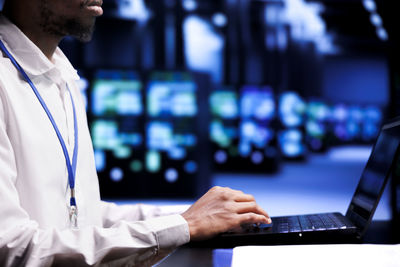 Midsection of businessman using laptop at office