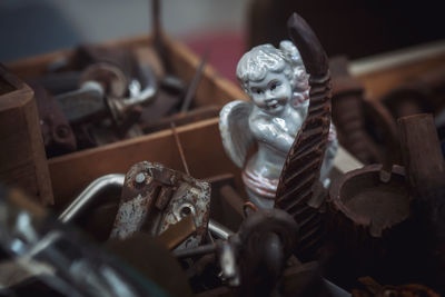 High angle view of statue amidst rusty metal in box