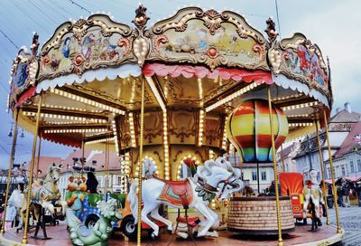 People in amusement park ride against sky