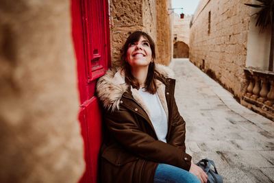 Portrait of smiling young woman in city