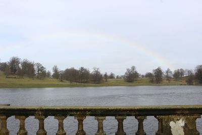 Scenic view of rainbow over lake against sky