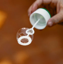 Close-up of hand pouring drink in cup