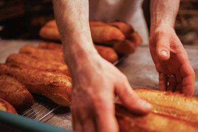 Cropped hands of chef preparing baguettes 