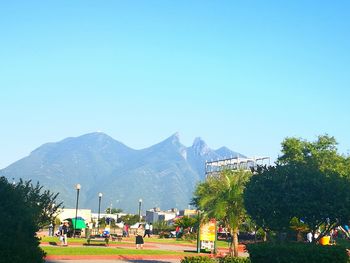 People on mountain against clear blue sky