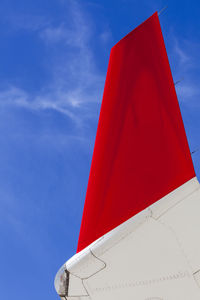 Airliner wing tip against a deep blue sky