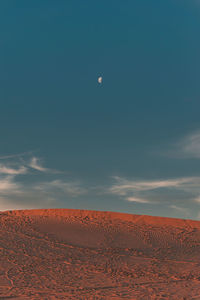 Scenic view of desert against sky and moon