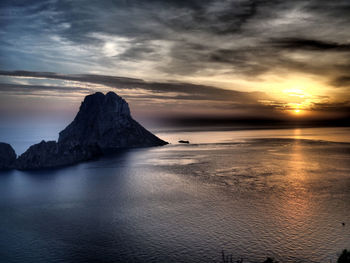 Scenic view of sea against dramatic sky during sunset