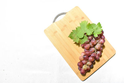 High angle view of grapes on table against white background