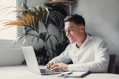 Young woman using laptop at table