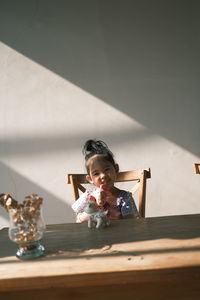 Portrait of girl sitting on table