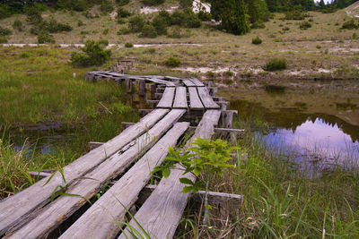 Wooden structure on field by lake