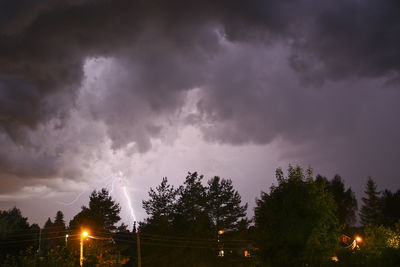 Low angle view of illuminated street light against cloudy sky