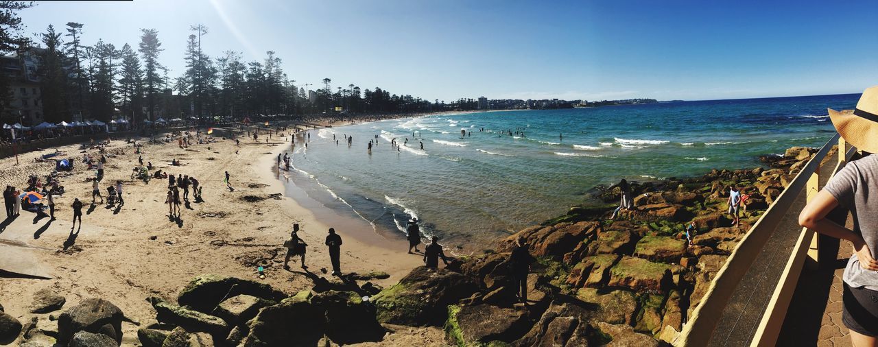 large group of people, water, sea, tree, beach, vacations, high angle view, leisure activity, lifestyles, panoramic, tourist, tourism, travel destinations, tranquil scene, blue, tranquility, nature, scenics, enjoyment, non-urban scene, day, weekend activities, beauty in nature, holiday - event, wide angle, sky