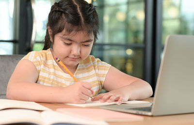 Young businesswoman using laptop at home