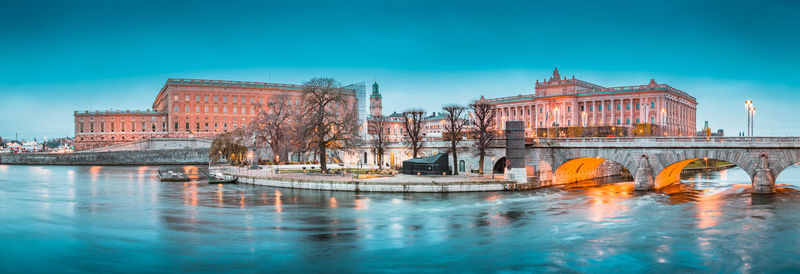 Arch bridge over river against buildings in city