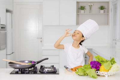 Cute girl making food in kitchen at home