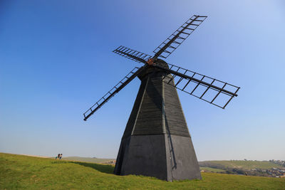 Traditional windmill on field against sky