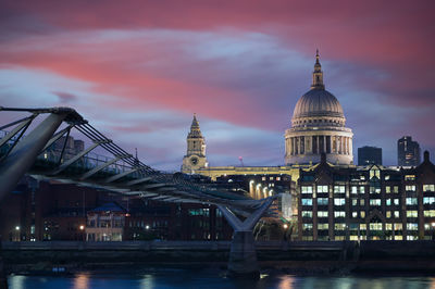 Bridge over river against sky in city