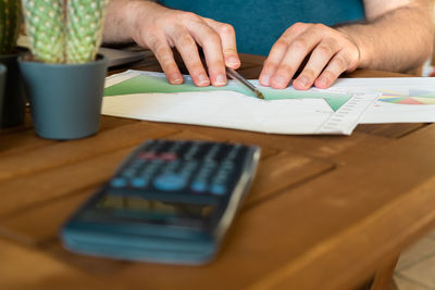 Midsection of woman using smart phone on table