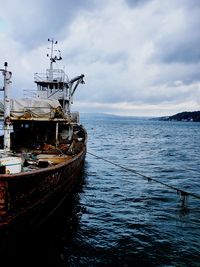 Boat moored on sea against sky