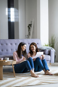 Woman sitting on sofa at home