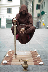  view of hooded man levitating above street
