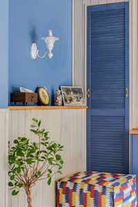 Blue interior with wood trim with small wood and colored ethno pouf