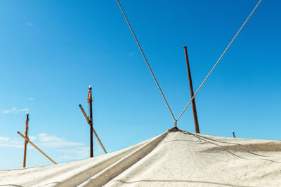 Low angle view of ship cables against clear blue sky