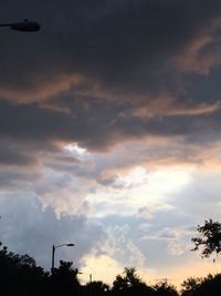 Silhouette of trees against cloudy sky