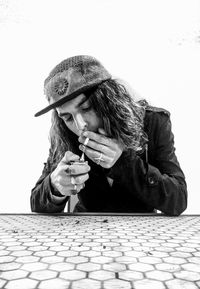 Man igniting cigarette while sitting at table