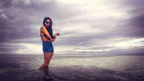 Full length of man standing on beach against sky