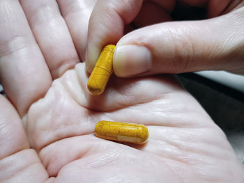 Cropped hand holding capsules