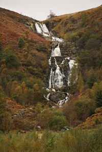 Scenic view of waterfall against sky