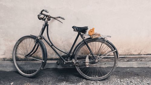 Bicycle parked against wall in city