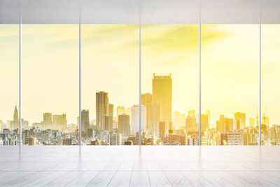 Cityscape seen through glass window during sunset