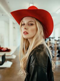 Portrait of beautiful woman standing against red hat