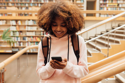 Portrait of smiling young woman using mobile phone