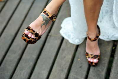 Low section of woman wearing leopard print sandals
