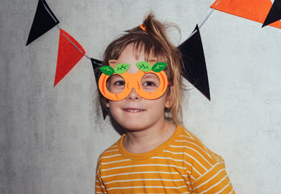 Portrait of a cheerful child in carnival glasses in the form of pumpkins. halloween holiday concept.