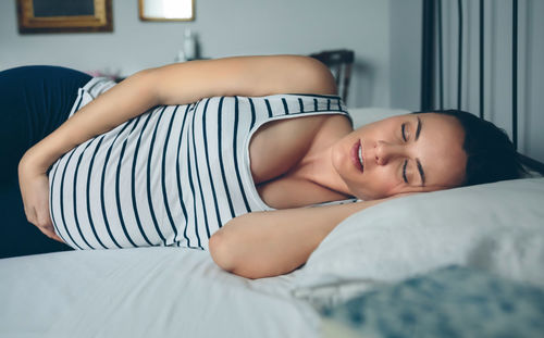 Pregnant woman lying on bed