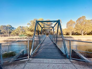 Footbridge against clear blue sky
