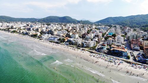 High angle view of town by sea against sky