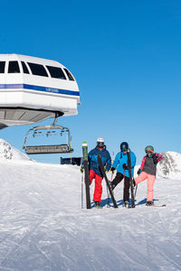 People skiing on snowcapped mountain against clear sky