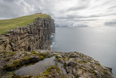 Rock formations by sea against sky