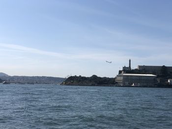 Birds flying over sea against sky