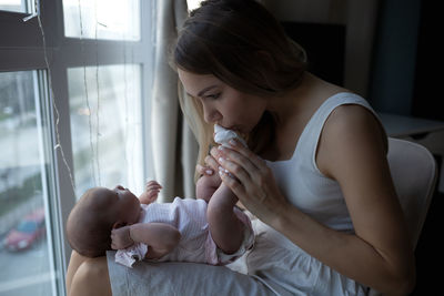 Side view of mother and daughter at home