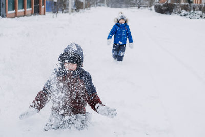 Outdoor winter activities for kids. kids playing in the suburbs, winter backyard gathering. boys