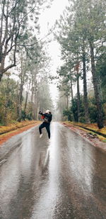 Man riding motorcycle on road in forest