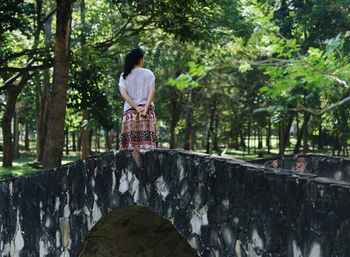 Rear view of woman standing on bridge