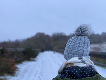 Rear view of woman wearing a knit hat walking in winter